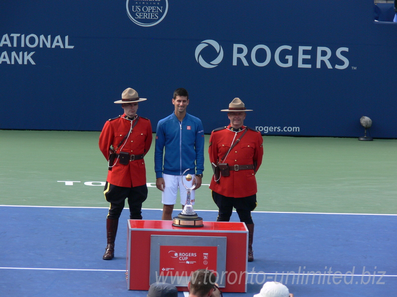 Novak Djokovic with Championship Trophy and RCMP Honor Guard on Centre Court of Aviva Centre