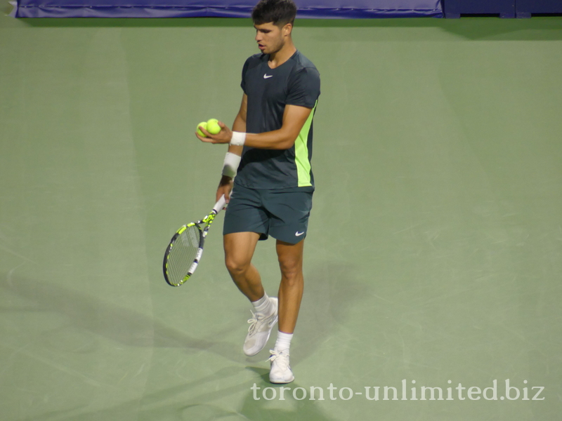 Carlos ALCARAZ (ESP) [1] is selecting a ball to serve